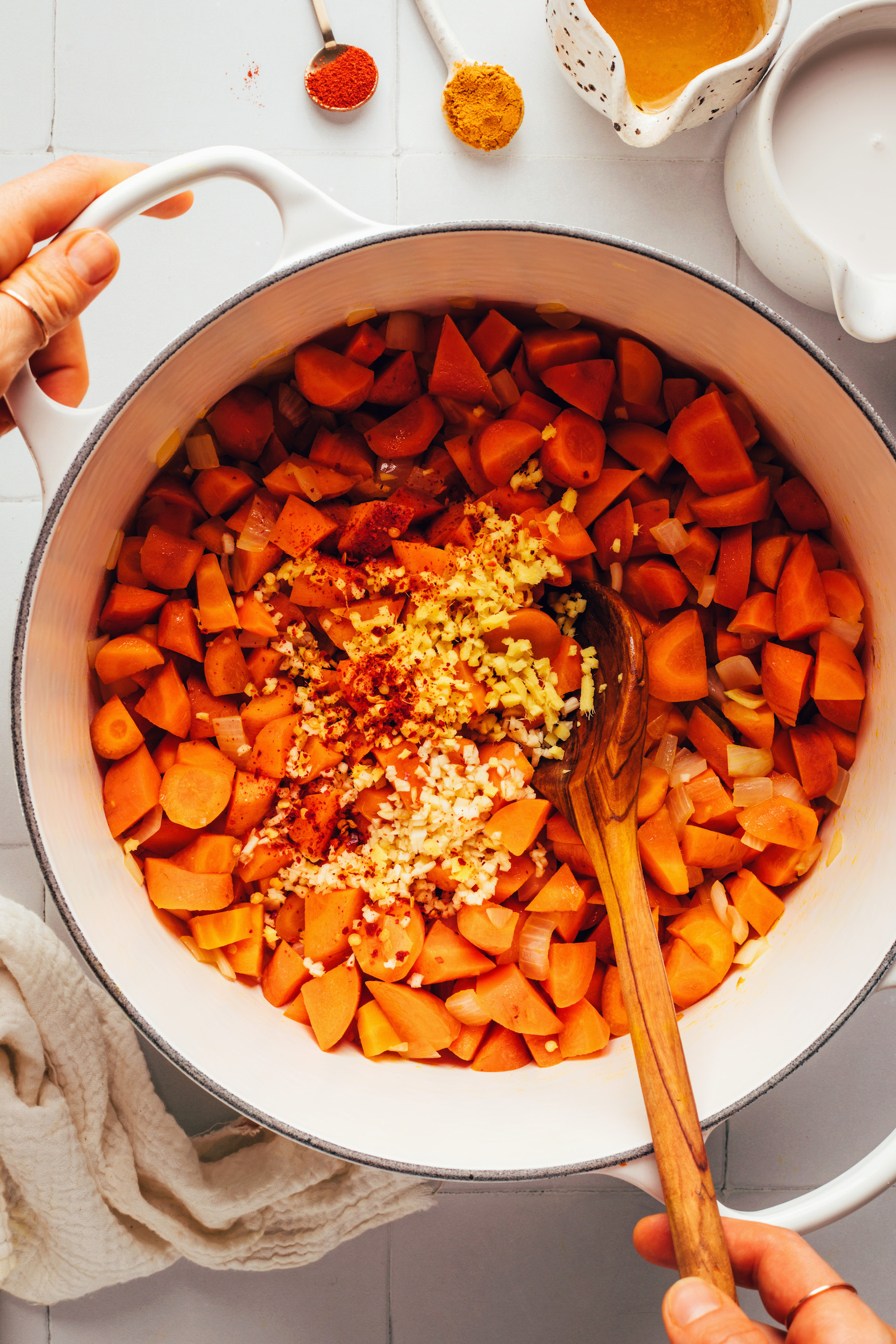 Pot of chopped carrots, sautéed onion, minced ginger and garlic, and spices