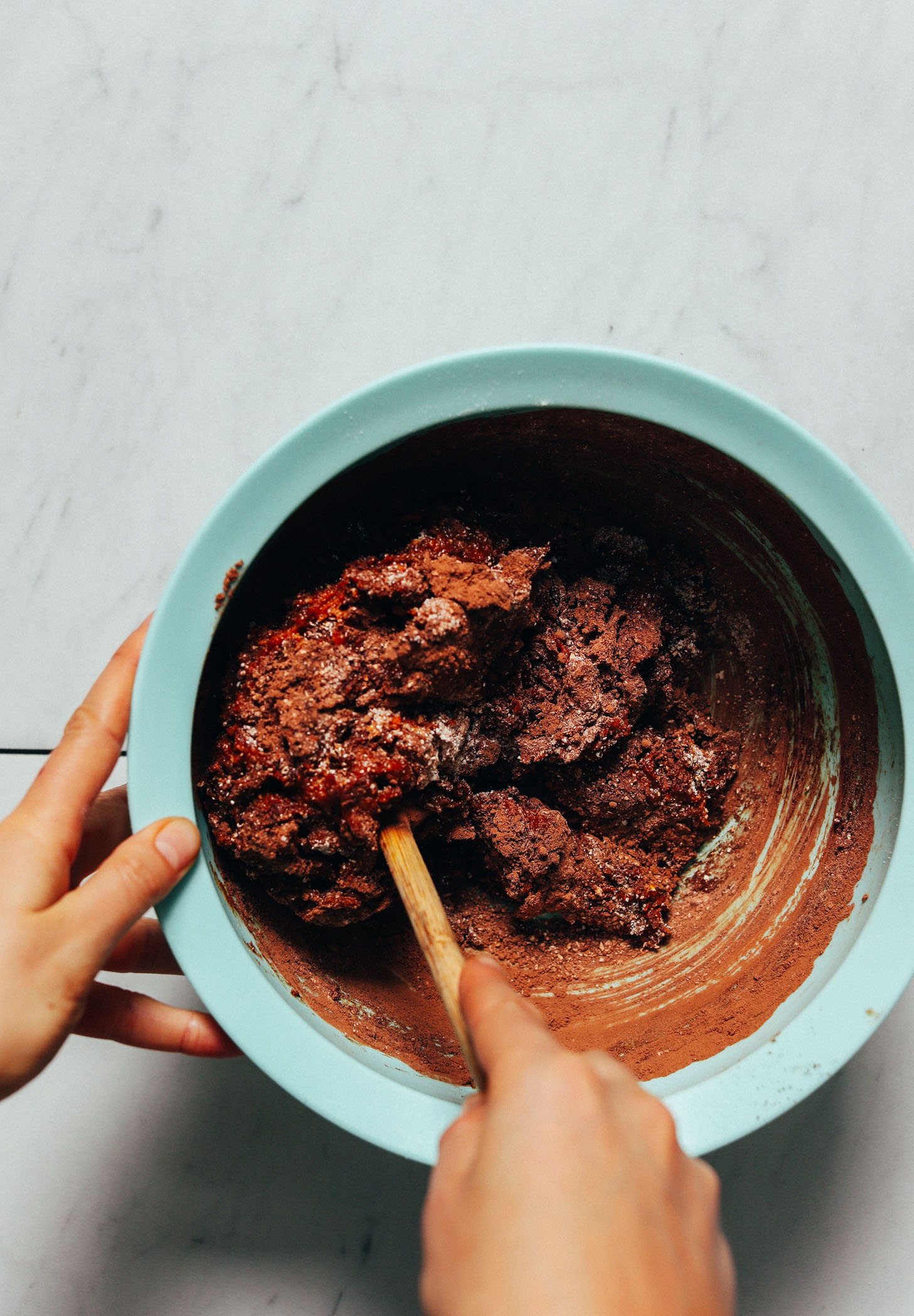 Using a wooden spoon to mix batter for making vegan Sweet Potato Brownies