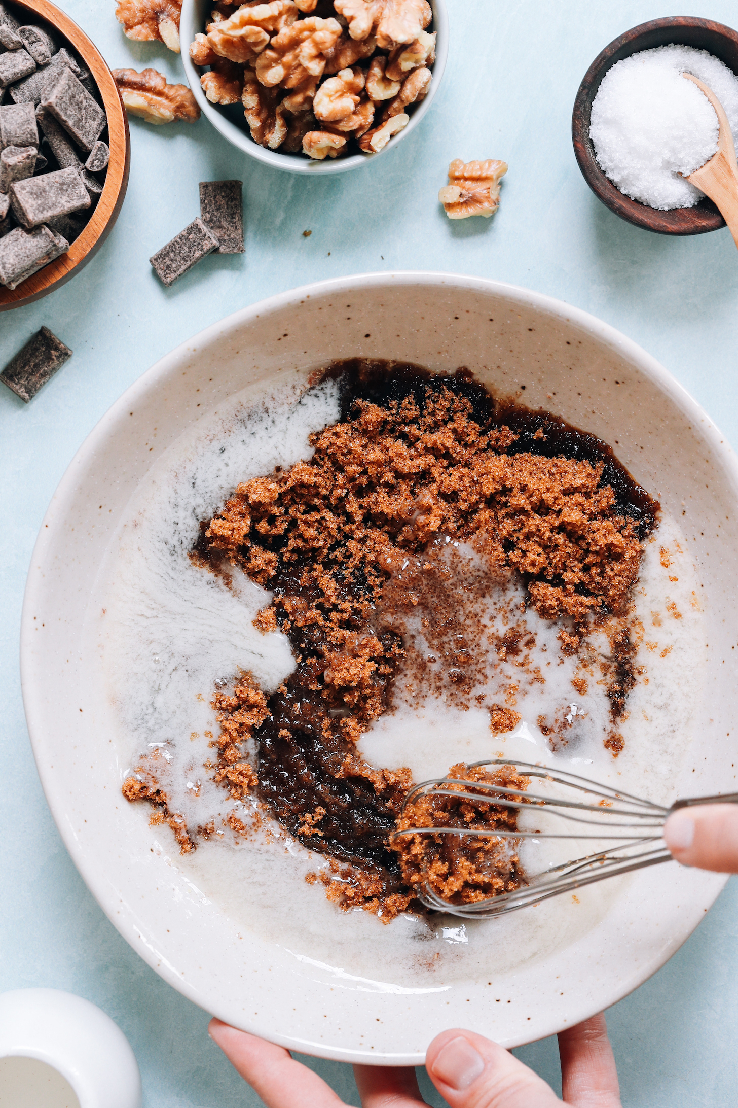 Whisking brown sugar, melted vegan butter, and other wet ingredients in a bowl