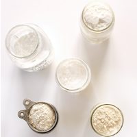 Jars and measuring cups of gluten free flours for making a homemade Gluten Free All Purpose Flour Blend