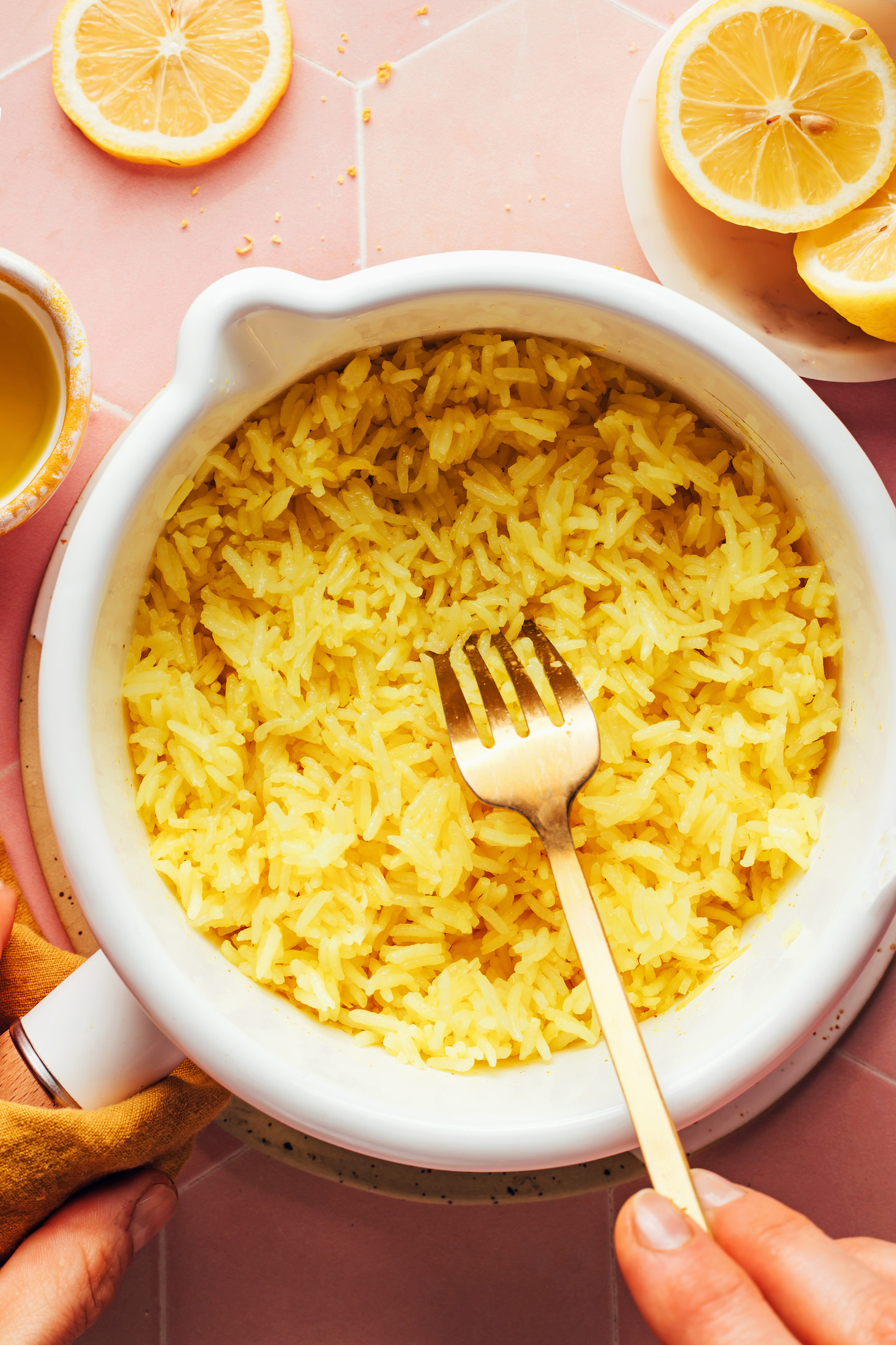 Using a fork to fluff a saucepan of lemon rice