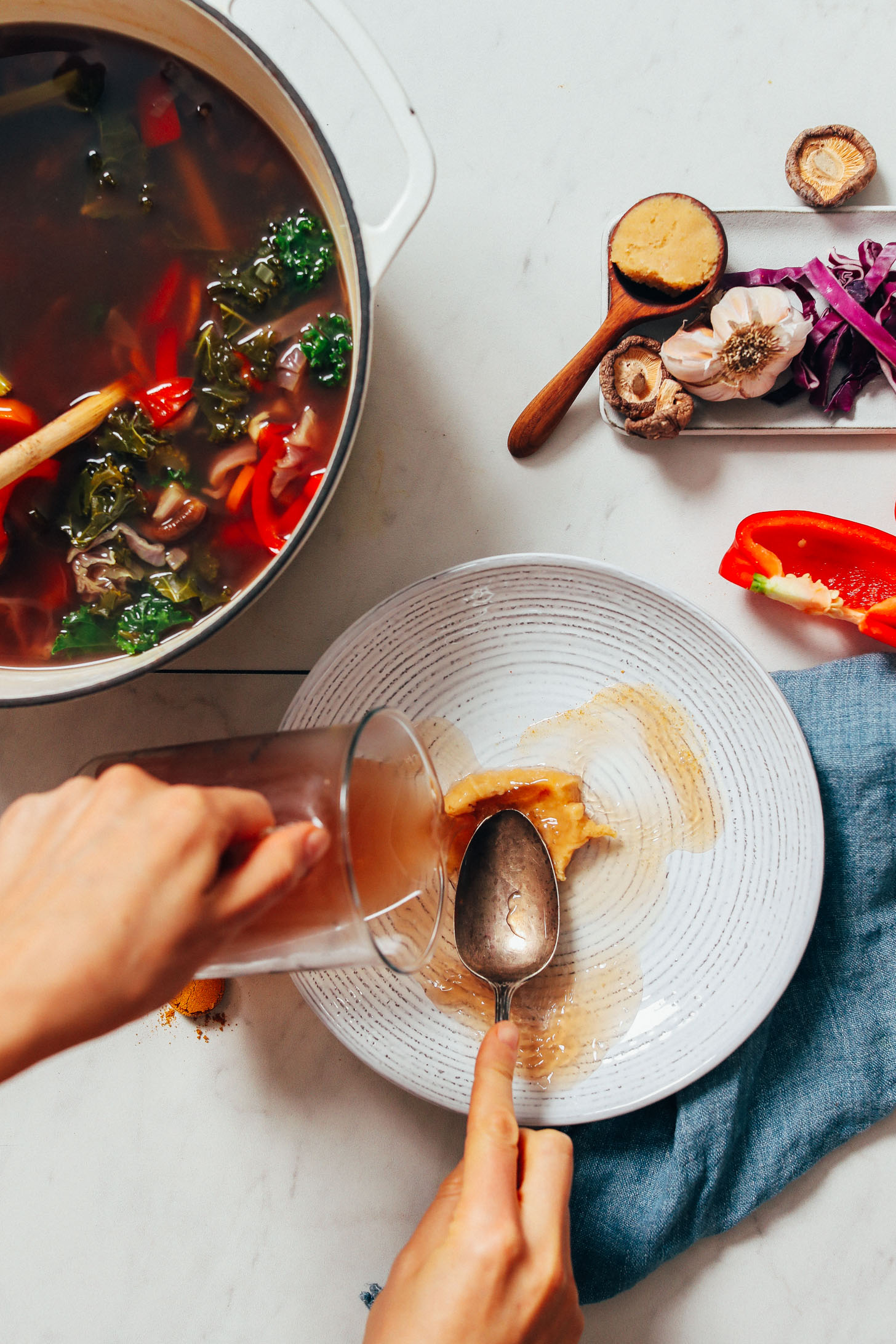 Pouring vegetable broth over chickpea miso in a bowl