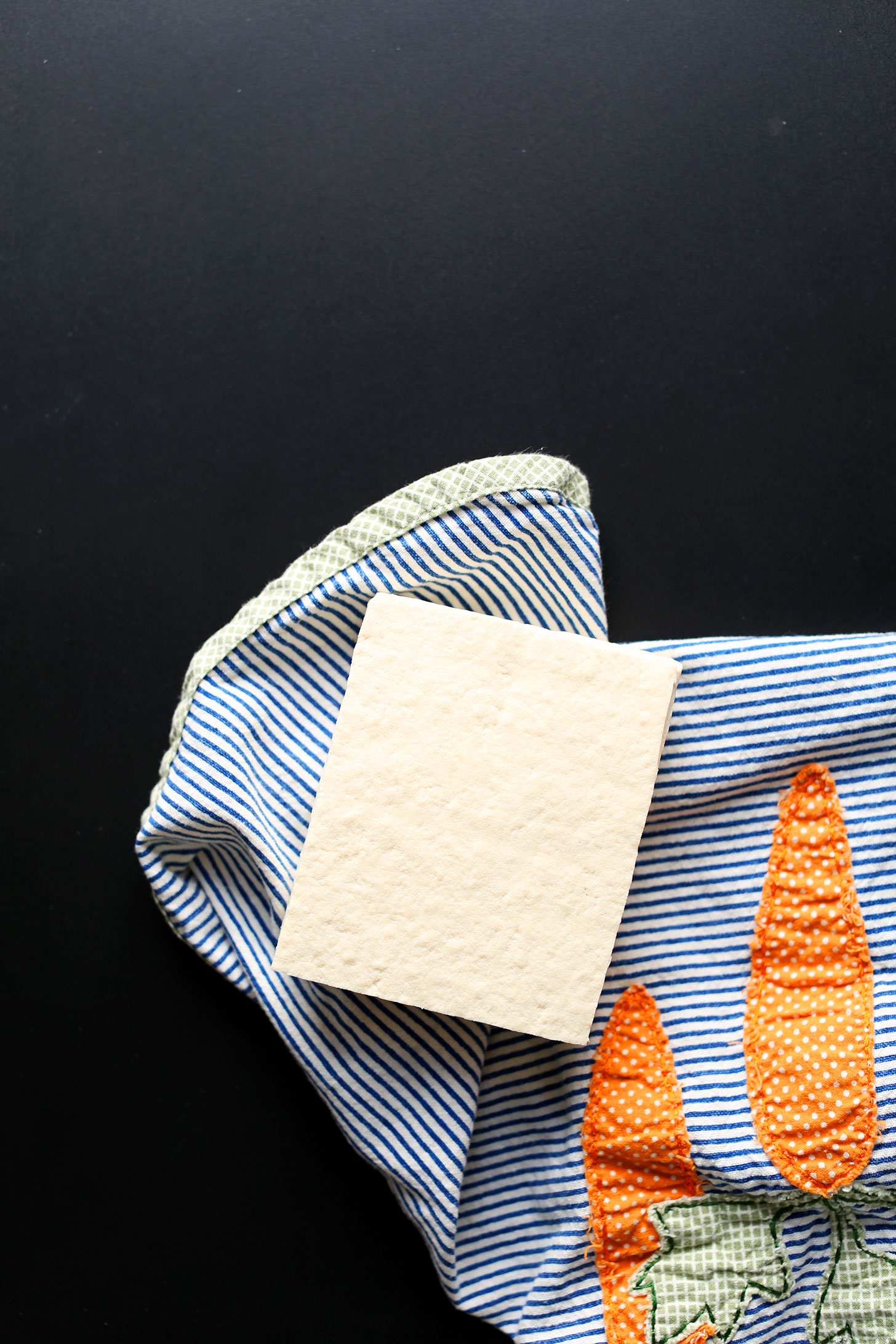 A block of tofu on a towel to show one of the steps for how to make the best crispy tofu