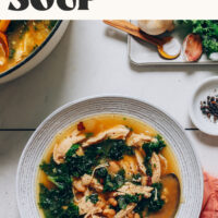 A bowl of our 1-pot white bean chicken soup next to ingredients used to make it