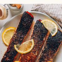 Plate of crispy skin salmon with lemon slices on top