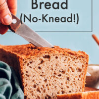 Knife slicing a loaf of vegan and gluten-free no-knead sandwich bread