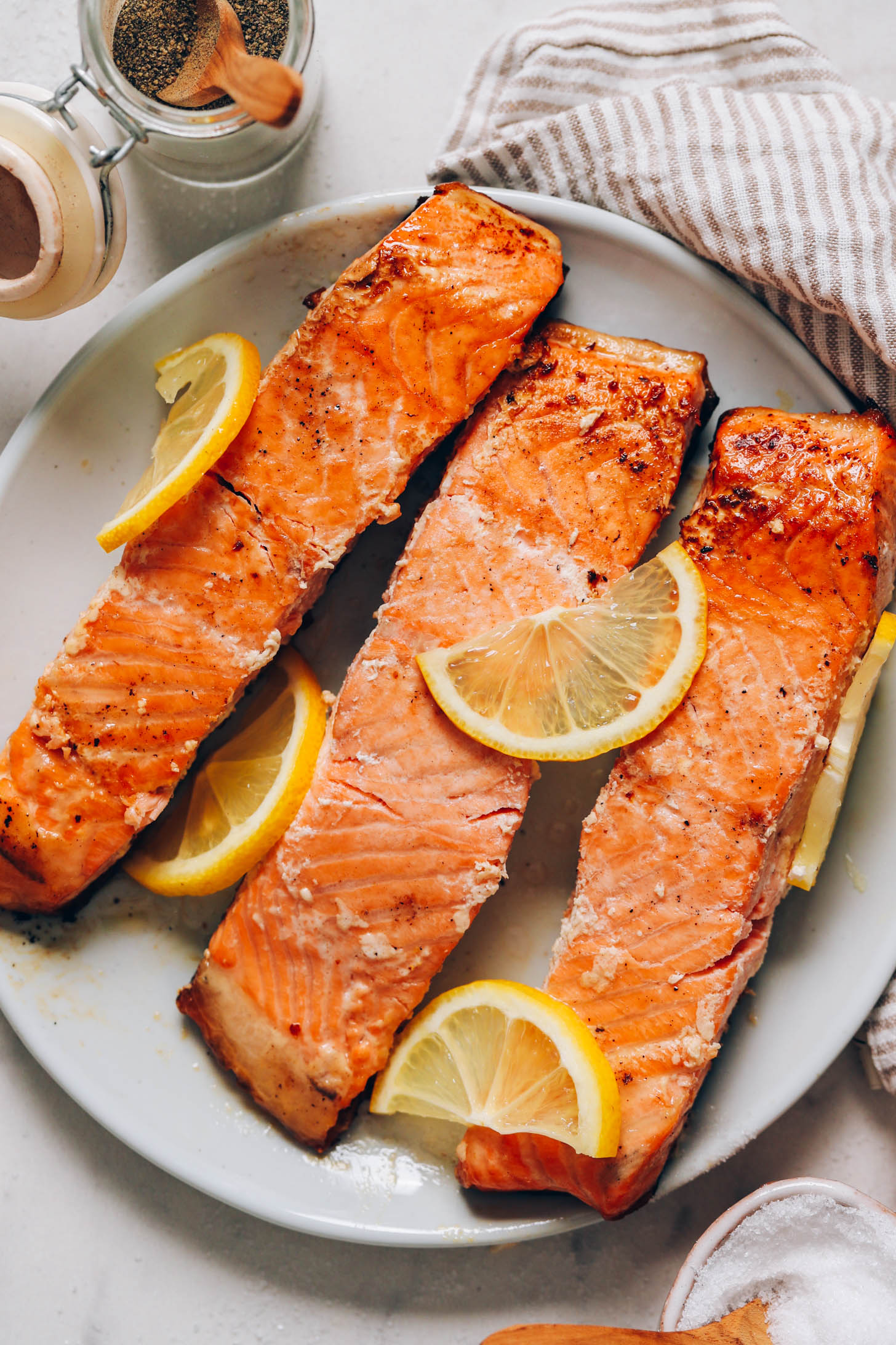 Plate of flaky salmon filets topped with lemon slices