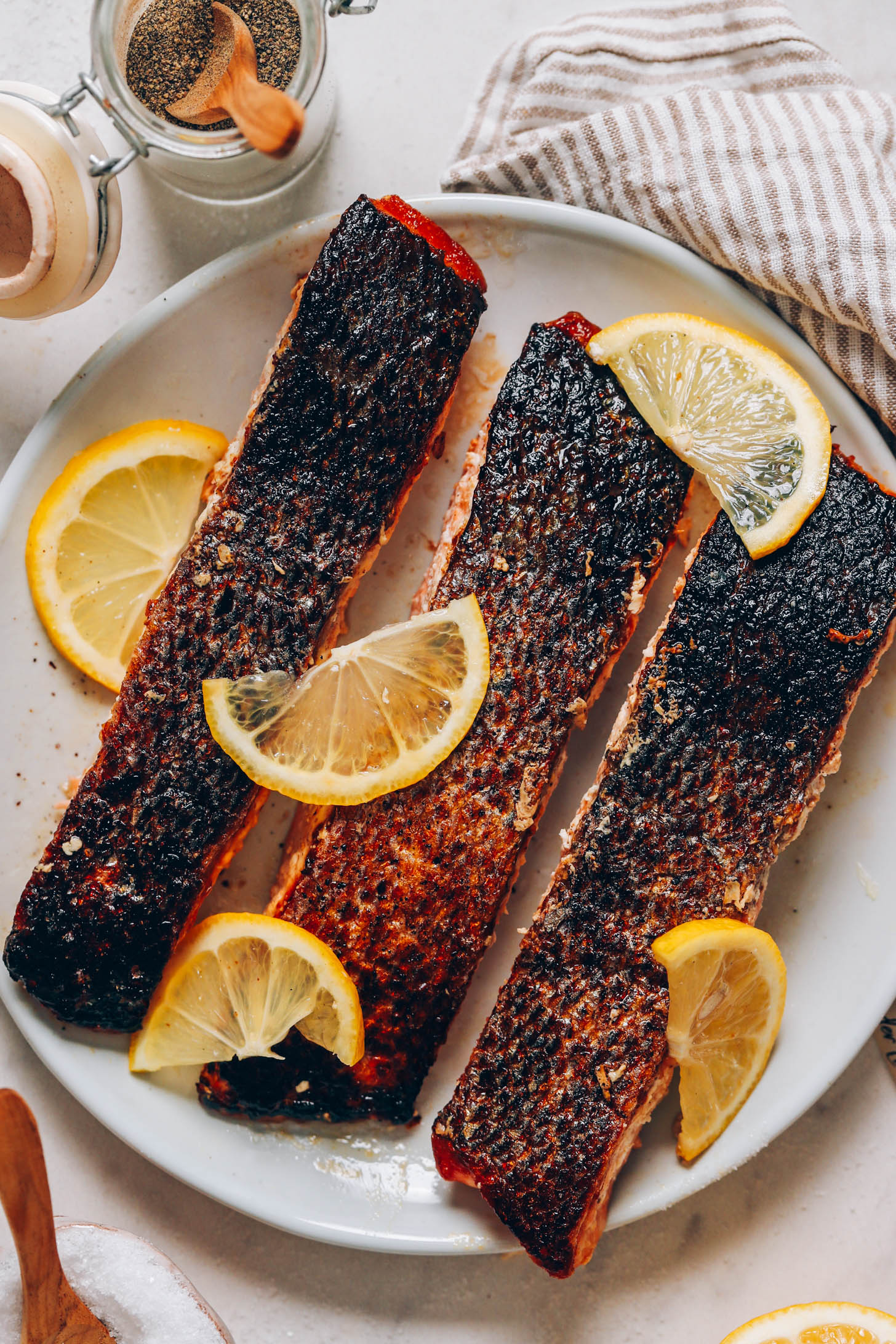 Plate of crispy skin salmon filets served skin side up with lemon slices