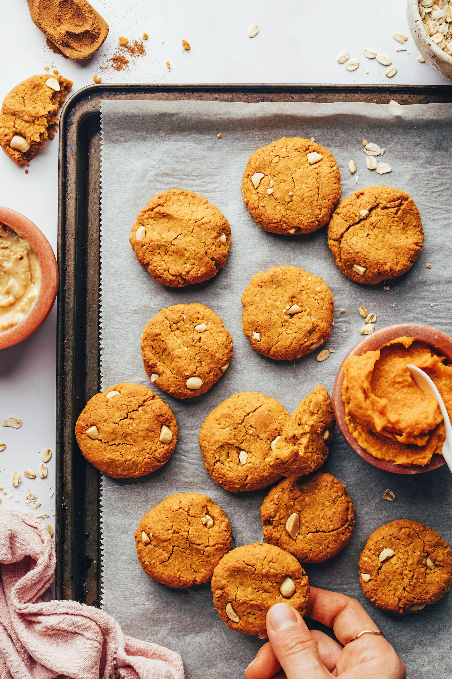 Pumpkin purée on a baking sheet next to peanut butter pumpkin breakfast cookies