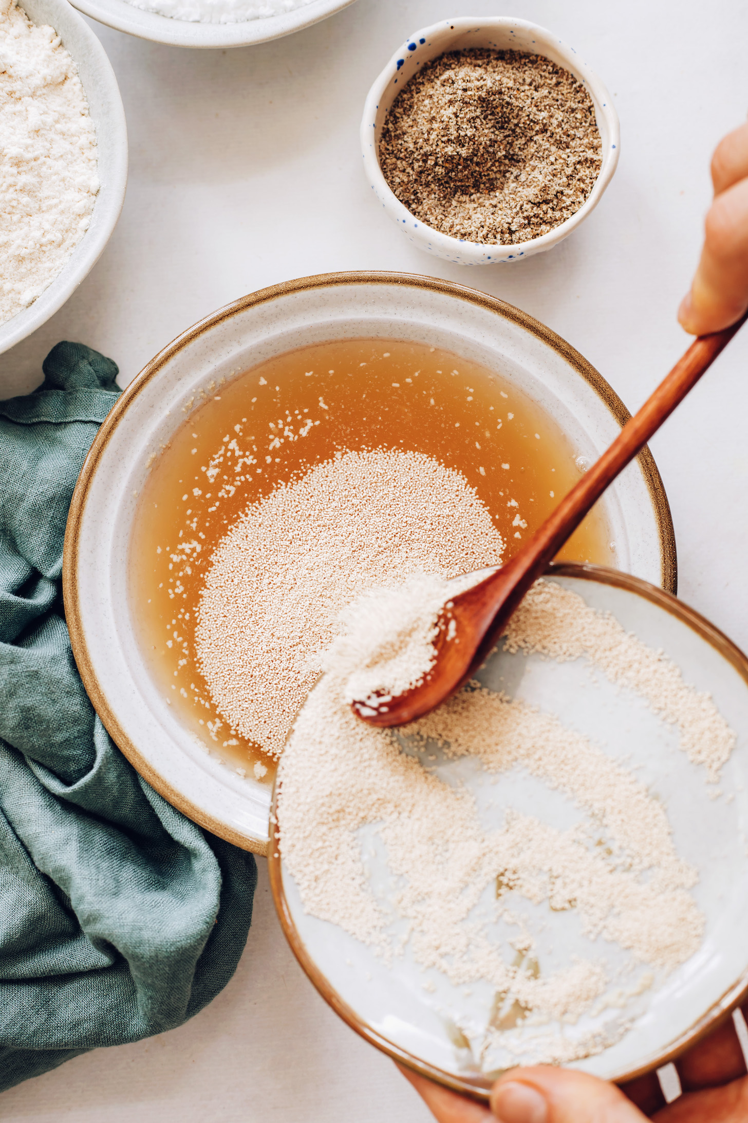 Adding yeast to a bowl of warm water