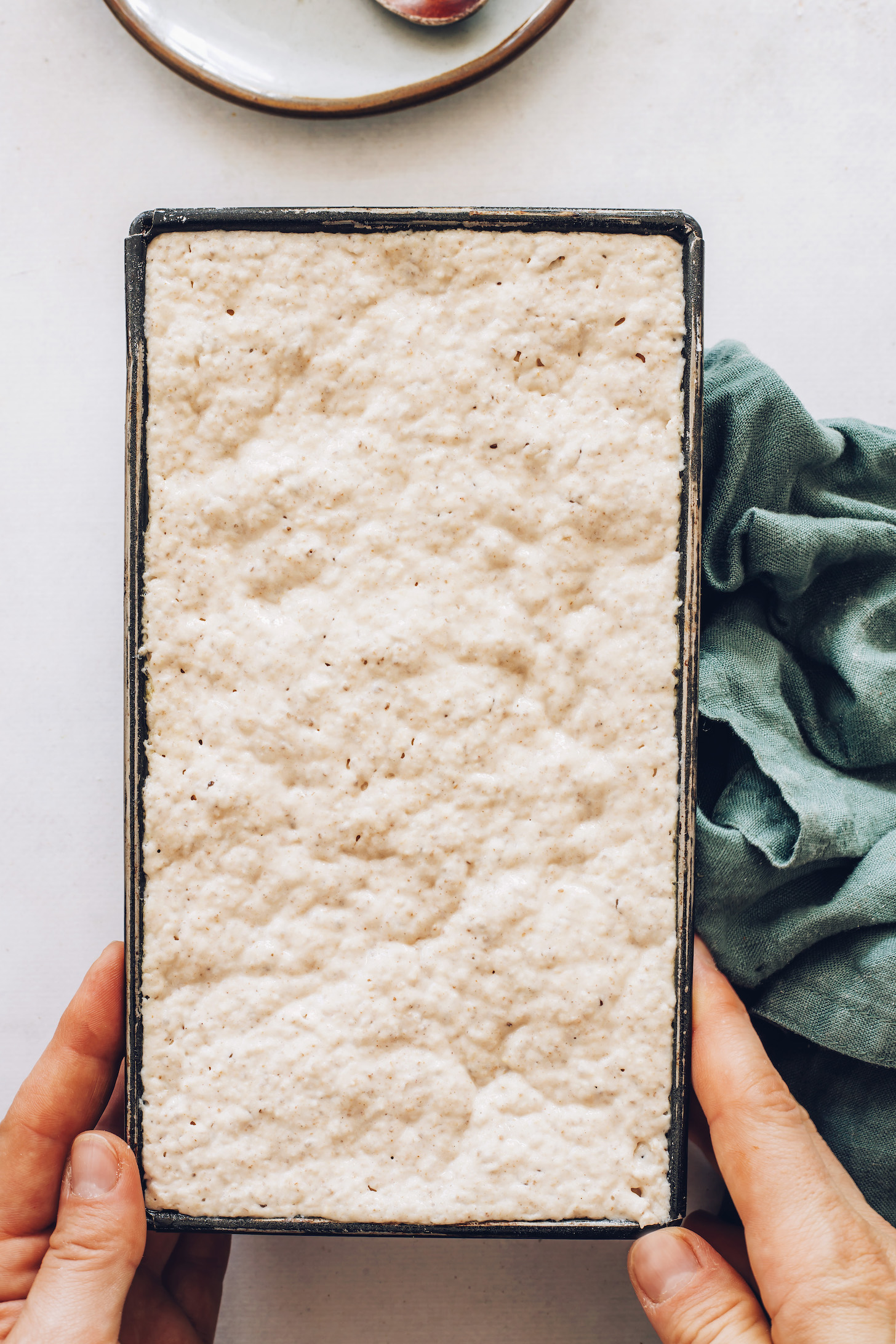 Loaf pan of gluten-free bread after rising