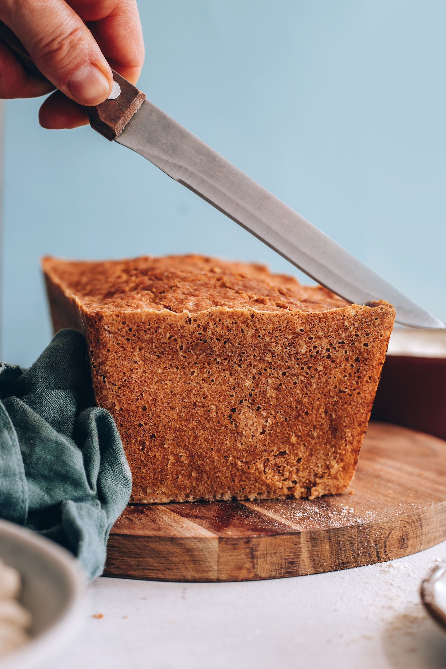 Slicing into a golden brown loaf of gluten-free bread