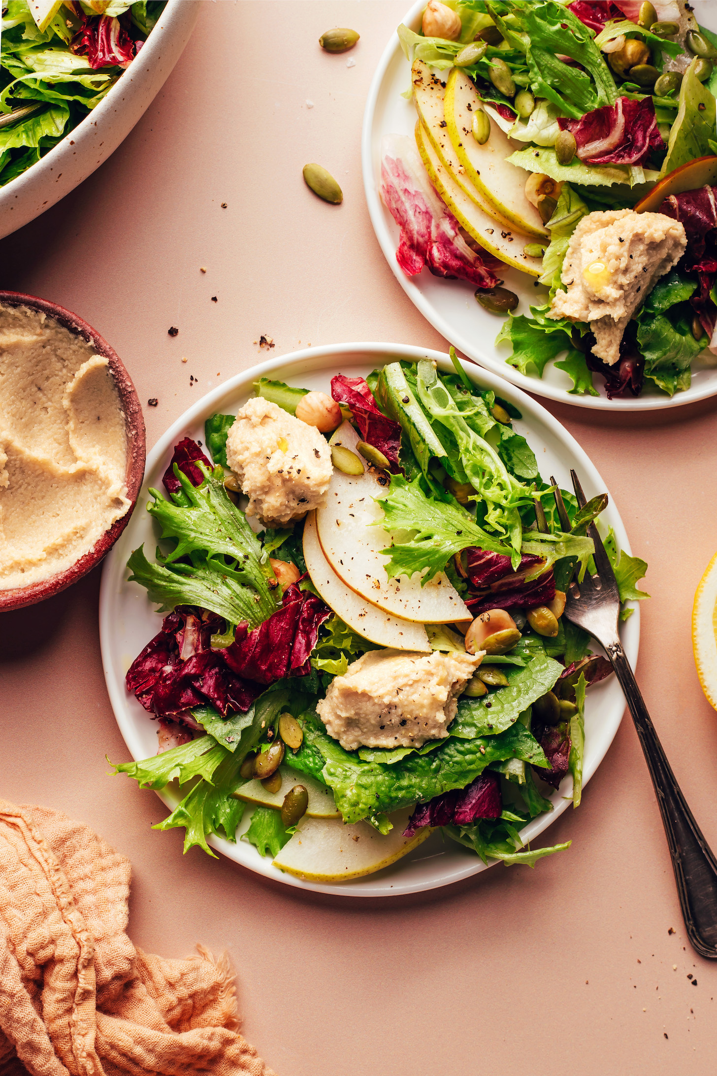 Two plates of our Thanksgiving chicory green salad topped with vegan goat cheese