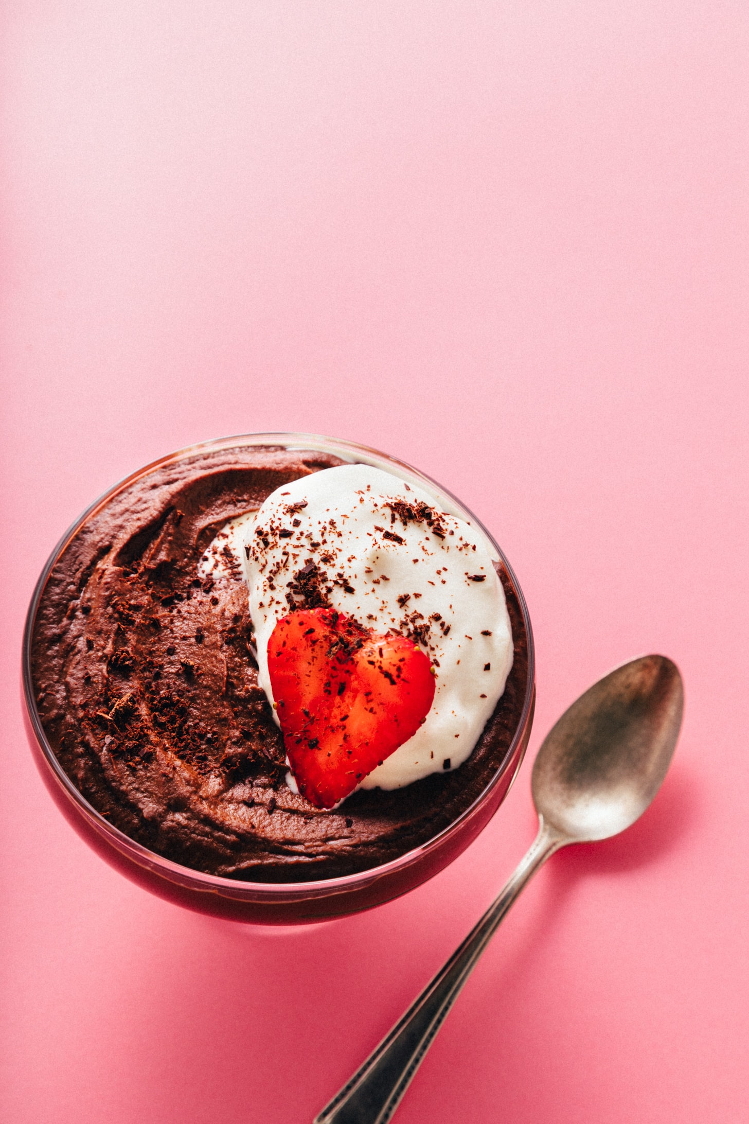 Overhead shot of a bowl of our Vegan Chocolate Protein Pudding with a fresh strawberry and coconut whipped cream