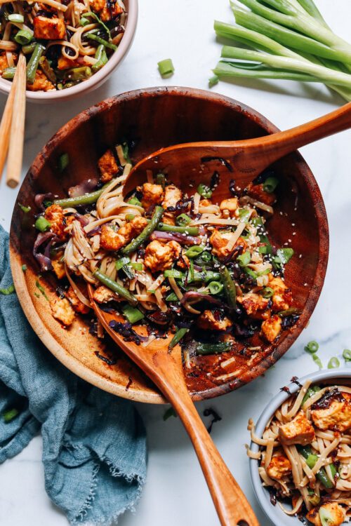 Large bowl and serving bowls of our tofu noodle stir fry recipe made on a sheet pan