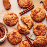 Overhead photo of apple butter snickerdoodle cookies next to cinnamon sticks and a bowl of apple butter