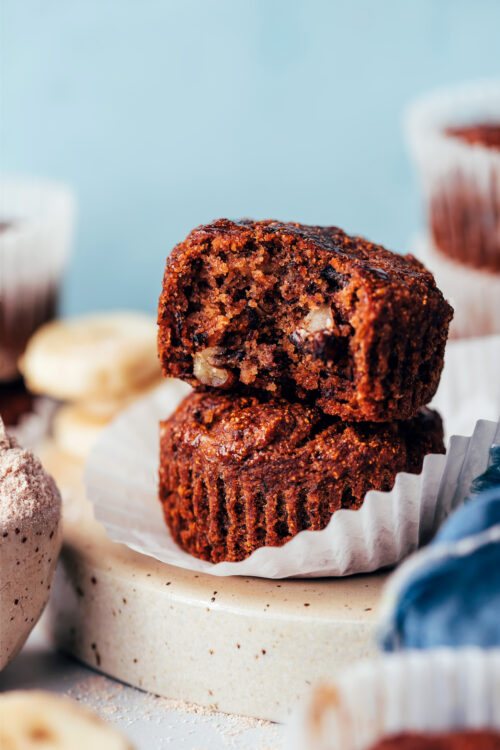 Stack of two banana buckwheat muffins with the first one partially eaten to show the texture