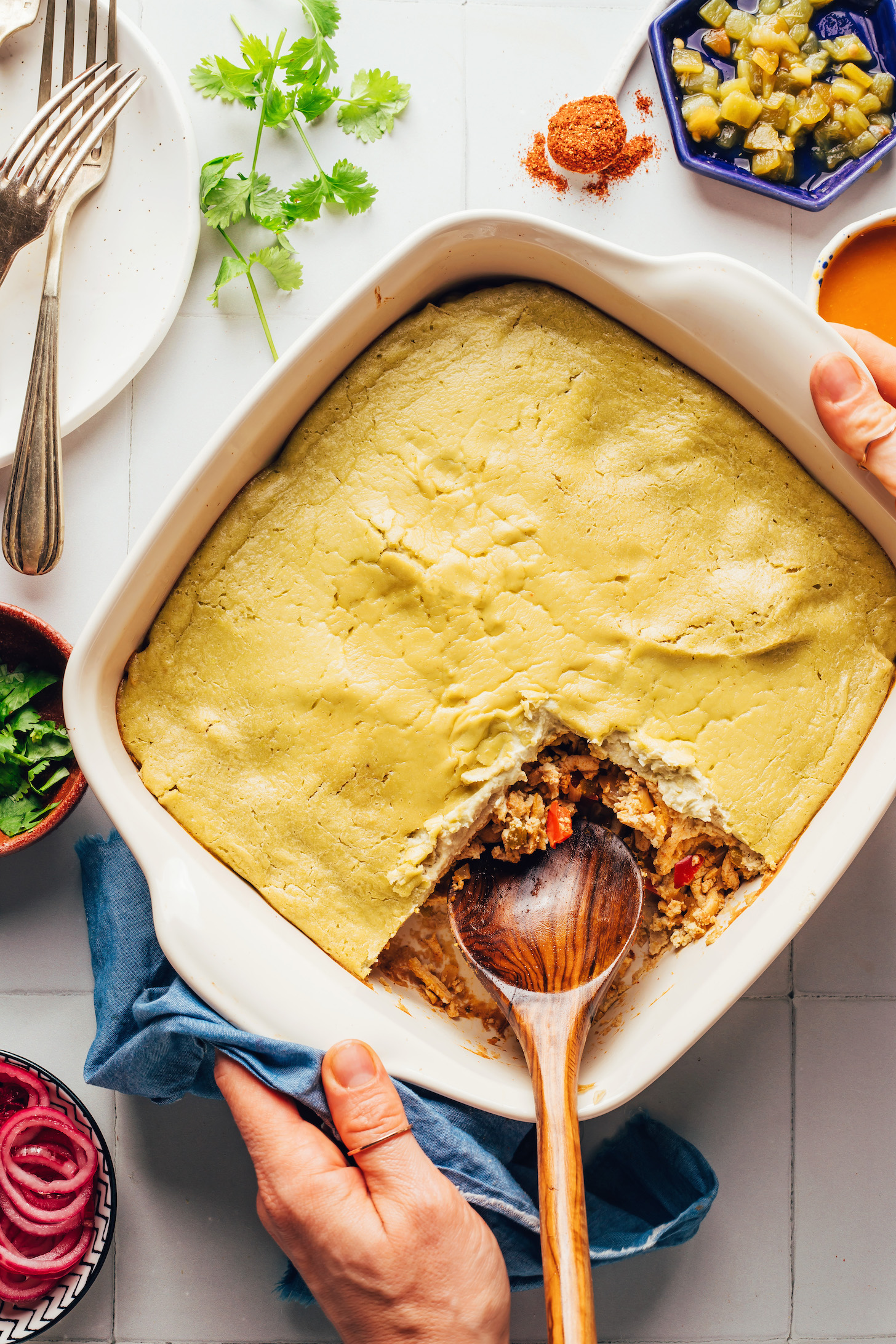 Holding a ceramic dish filled with our creamy vegan green casserole